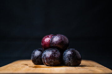 A bunch of plums on a wooden board