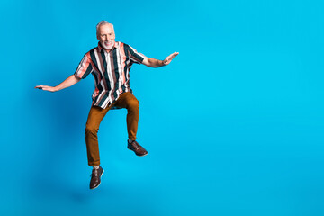 Photo of cheerful glad good mood senior man wear striped stylish clothes blank space isolated on blue color background