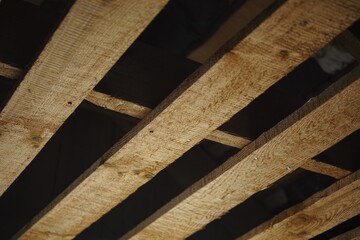 Wooden planks under the roof of a house that is under construction.