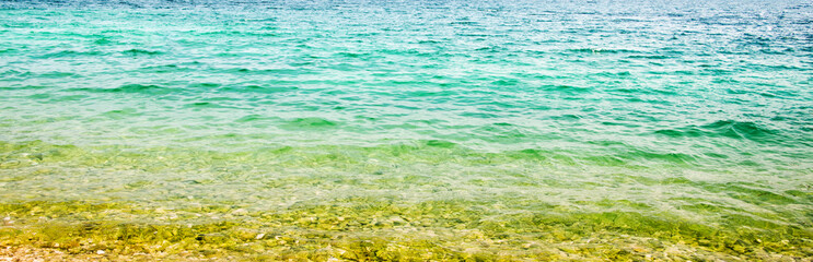 Clean, transparent sea surface of the sea in bright sunlight, texture of sea water