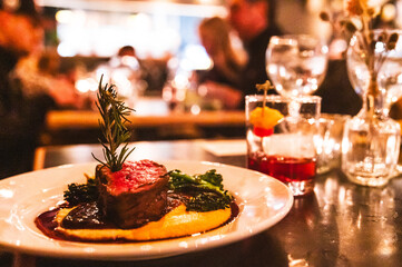 beef tenderloin served on a plate of pureed sweet potatoes and greens in a restaurant