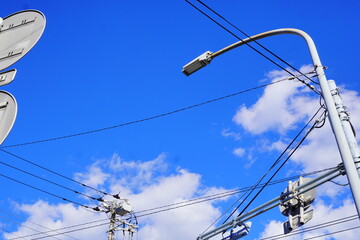 春の昼下がりの空。青空に浮かぶ綺麗な雲と電信柱。