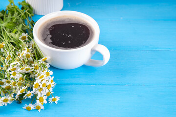 Chamomile daisy flowers bouquet, book, tea or coffee cup, relaxation holiday simple life enjoy summer background, on light blue wood background, top view copy space. Good day, good morning wishing - obrazy, fototapety, plakaty