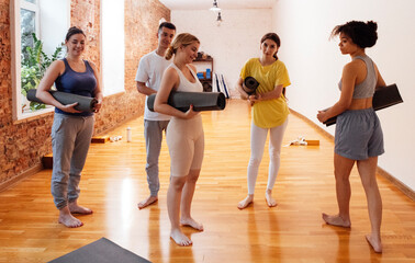 Fototapeta premium A group of multiethnic athletes roll up mats after yoga classes.