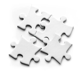 Obraz premium Puzzle pieces scattered on the table with a clean white background, closeup detail. 