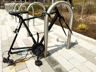 abandoned locked bicycle with stolen wheels, street vandalism