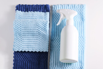 Cleaning product with a sprayer on a background of a blue microfiber cloth.