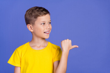 Photo of cute cheerful nice small boy wear stylish yellow clothes recommend proposition empty space...