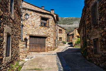 Narrow picturesque alley with stone houses next to the mountains of central Spain.