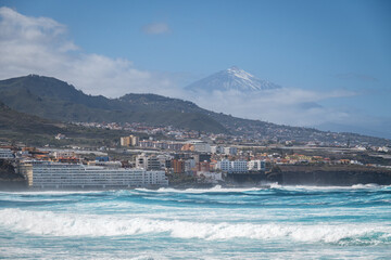 Coast with waves of Bajamar with vulcano Pico del Teide in the background, Tenerife, Canary Islands, Spain