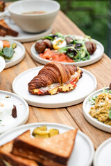 Gourmet Breakfast Spread Featuring Croissant Sandwich and Assorted Dishes