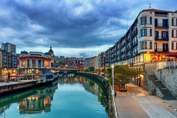 Colorful residential and apartment buildings and restaurants along the Nervion River in Bilbao,...