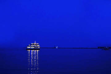 A lonely passenger pleasure boat at sea at dusk.