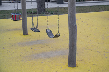 children's playground with swings and yellow rubber floor
