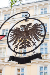 Coat of arms of Austria on the facade of a house with a Gothic residential tower in Vienna