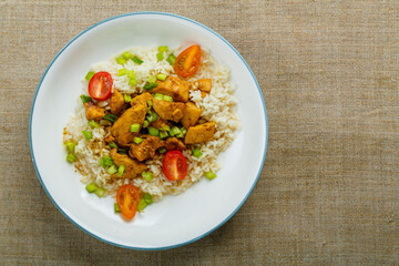 Thai chicken with rice in Pad Thai sauce on a plate on the table. copy space