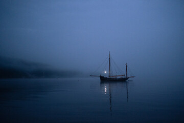 Sailboat at sea during a foggy night