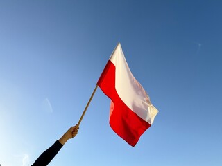 Polska flaga biało-czerwona powiewająca na wietrze na tle błękitnego nieba. Dzień Flagi, Święta Narodowe, 3 Maja, patriotyzm.