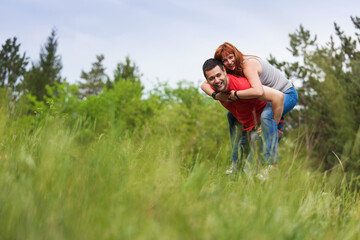 Young couple in a grass field having fun