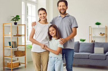 Portrait of happy loving nuclear family at home. Mother, father and child spend time together....