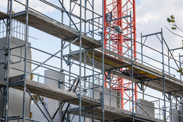 Detailed shot of a scaffolding with a crane in the background