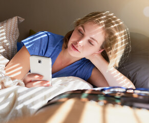 Woman, bed and relax with phone for search on social media, technology or video call in bedroom. Female person, mobile and scroll for news on digital in Europe, check with application for new story