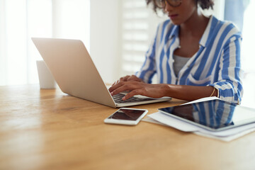 Woman, laptop and work from home for blog, social media and email in apartment. African female...