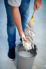 Person, hand and mopping bucket for cleaning with soap as janitor service for health, bacteria or...