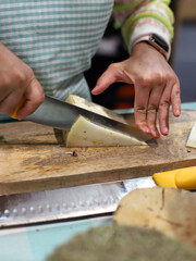 quesero profesional partiendo queso con un cuchillo