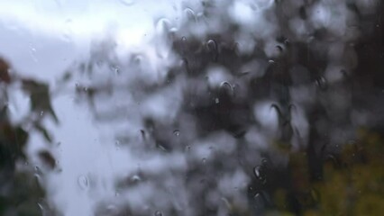 Raindrops on window in storm on view from home