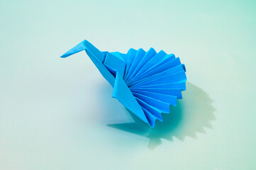 Blue colored isolated origami peacock.