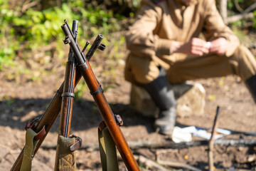 WWII rifles propped up against each other in a military camp