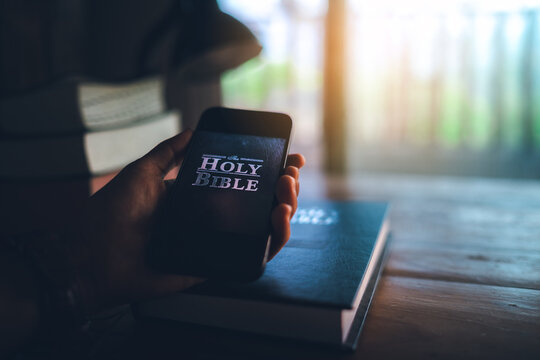 hand holding smart phone for read bible app. ready to study the Bible in the teachings of God.