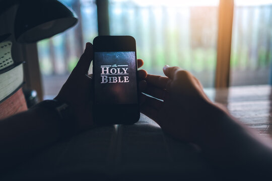 hand holding smart phone for read bible app. ready to study the Bible in the teachings of God