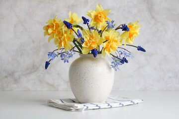 spring flowers, daffodils and hyacinths in a white vase. spring bouquet.