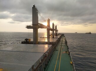Bulk carrier ship at sunset with carne, Clam sea