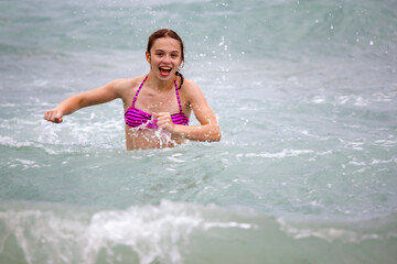 Teenage girl running through waves