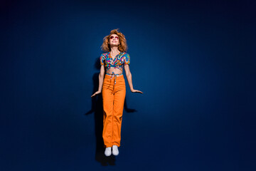 Full size photo of pretty young woman jumping empty space wear top isolated on dark blue color background