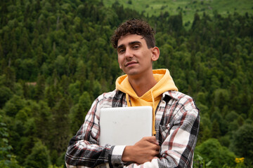 A young attractive student is resting in nature.