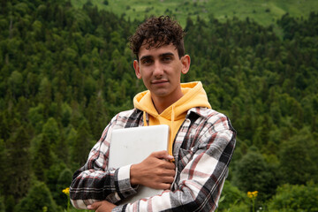 A young attractive student is resting in nature.