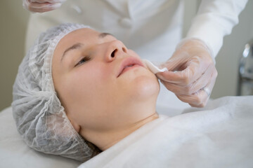 The cosmetologist's precise handwork preps for facial treatment. This step is vital for the success...