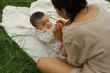 Mom and baby play on the grass, surrounded by nature s embrace. Capturing the trend towards...