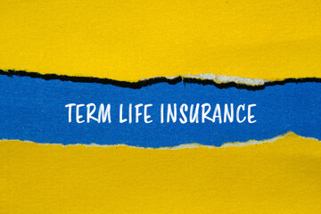 Term life insurance words written on ripped yellow paper with blue background. Conceptual term life insurance symbol. Copy space.