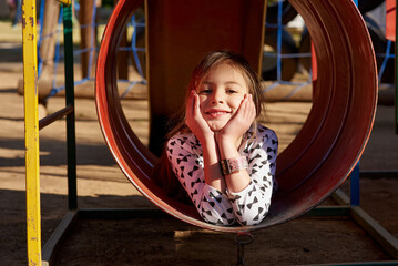 Portrait, slide and playground for child in nature, park and garden for play and fun. Face, freedom...