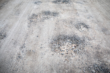 Gravel road with big potholes. Effects of weather and heavy use