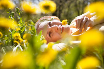  lifestyle portrait senior woman  with gray hair in headphones relaxeslying on the grass with...