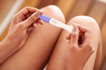 Woman, hands and pregnancy test with positive results of line, stick or examination at home....
