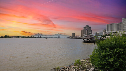 a gorgeous spring landscape along the MIssissippi River with boats sailing and the Crescent City...