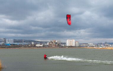 A kite surfer rides and jumps the waves the black sea