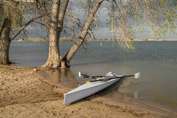 Coastal rowing shell on a shore of Boyd Lake in northern Colorado in early spring scenery.